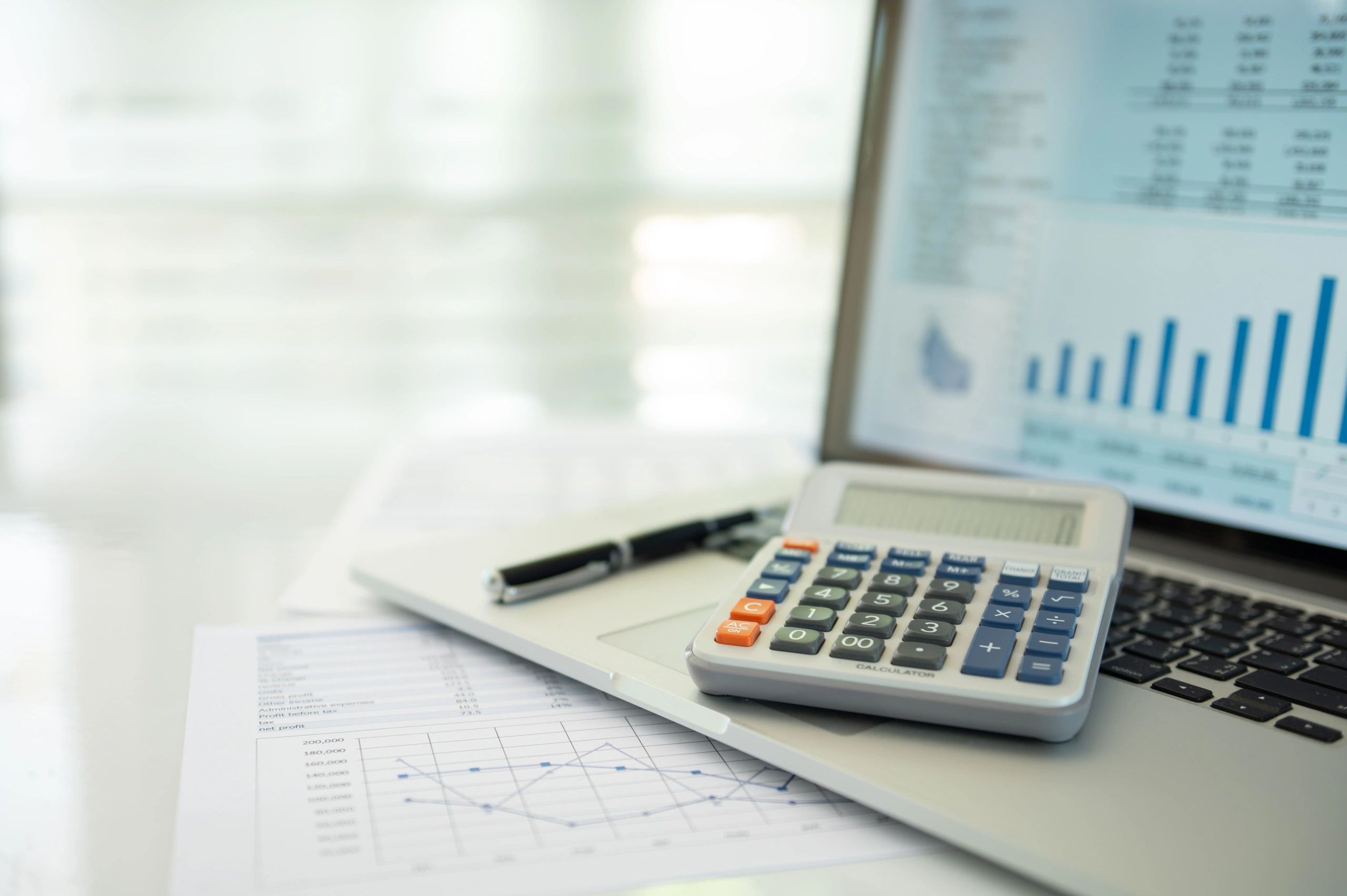 Financial reports and calculator on a laptop desk