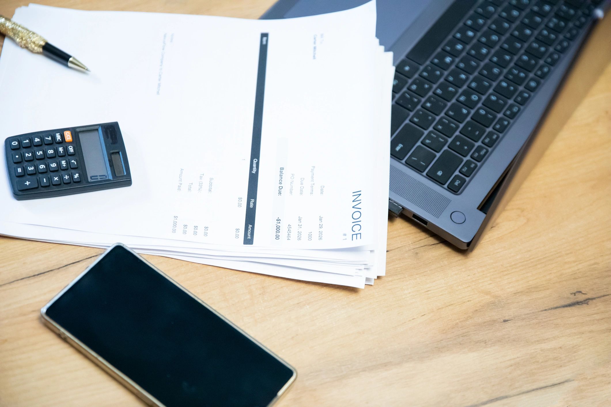 Laptop and stacked documents on a desk